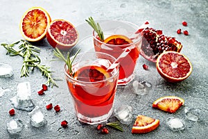 Red cocktail with blood orange and pomegranate. Refreshing summer drink. Holiday aperitif for Christmas party.