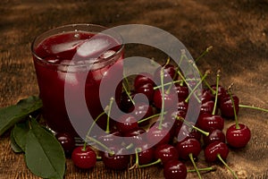 Red cocktail. Cherry juice with ice. Cherry leaves and cherry berries. The summer aroma of coolness in a glass. Juccy
