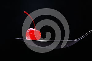 Red cocktail cherry on spoon