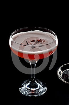 Red cocktail with foam and roses petal seen from above