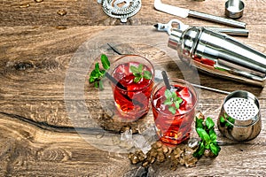 Red cocktail with ice, mint leaves and strawberry