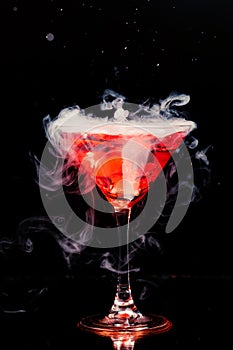 Red cocktail with ice vapor