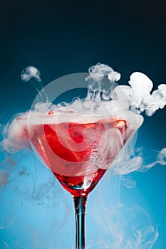 Red cocktail with ice vapor photo
