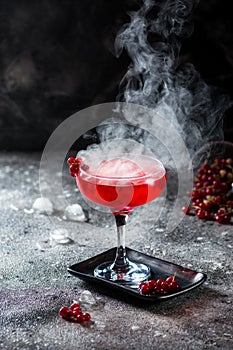 Red cocktail with ice vapor. Cocktail with smoke. Alcohol drink, vodka, ice, party, dry ice.