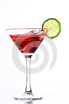 Red cocktail with lime on white