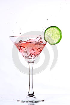 Red cocktail with lime on white