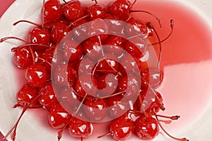 Red cocktail maraschino cherries on plate close up