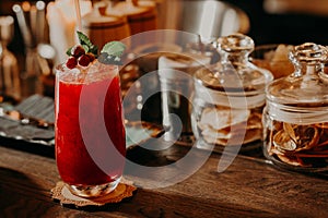 Red cocktail with mint on bar table
