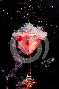 Red cocktail with splash and ice vapor photo