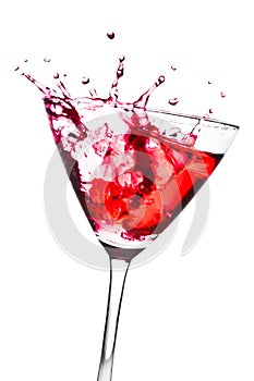 Red cocktail with splashing in the tilted glass