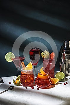 Red cocktails set: kir royale, negroni, boulevardier, cosmopolitan, sea breeze with fruits, berries and citrus. Bar tools. Dark