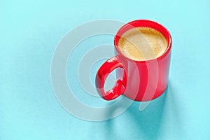 Red coffee cup on blue background with free space for text