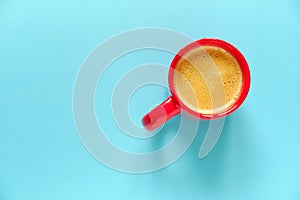 Red coffee cup on blue background with free space for text. Top view