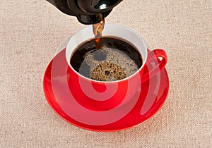 Red coffee cup filled with black expresso