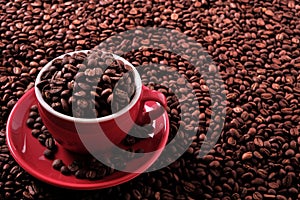 Red coffee cup filled with dark roasted beans