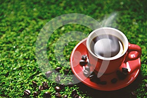 Red coffee cup on the green grass with copy space for text or advertising, Drinking concept, Love concept, Relax concept,