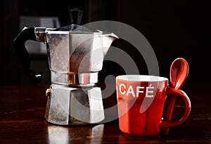 Red coffee cup and vintage coffeepot on wooden table