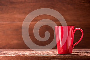 Red coffee cup on wooden table