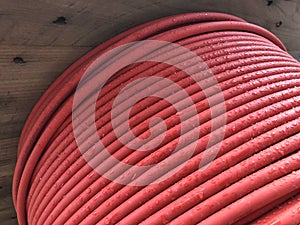 Red coiled electrical cable on the wooden spool