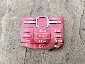 Red color broken mobile keypad put on road