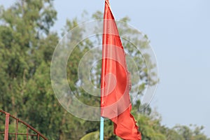 Red color flag made of cloth display under bright daylight.