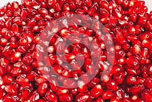 Red color fresh pomegranate berries. Berry texture. Pomegranate seeds on white background
