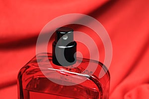 Red color men perfume bottle isolated on black background.