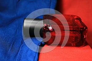 Red color men perfume bottle isolated on red and blue background.