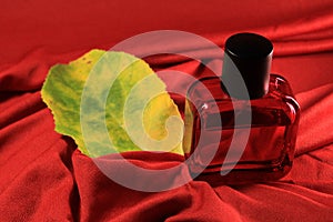 Red color men perfume bottle isolated on red silk background.