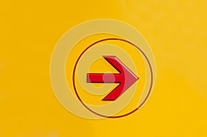 Red color paint arrow sign in white circle sharpe on yellow background. Go right arrow sign for direction