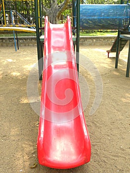 Red color slide at children`s playground