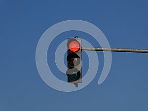 Red color on the traffic light with blue sky