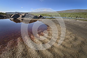 Red coloration in pool beside river due to iron, Sarek, Sweden photo
