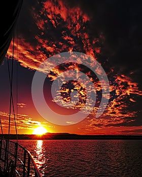 Red colored altocumulus cloud, sunset seascape.