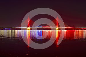 Red colored cable-stayed bridge at night.