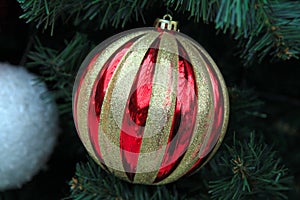 Red-colored Christmas ball on the smart and decorated Christmas tree