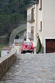 Red colored Classic car cruising on the road