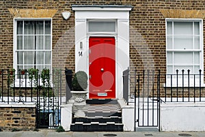 Red colored front door of a city house