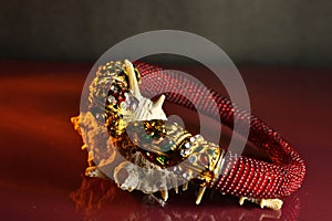 Red colored golden bangle golden jewellry on sea-shell