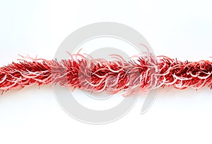 Red colors bunch fur or Christmas tree tinsel garland on white background. Christmas and New year celebration