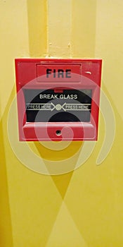 Red colour manual fire alarm system box on yellow wall