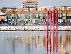 Red colour structure of four set of parallel poles erected in the centre of a lake. Season is Winter with lot of white snow. photo