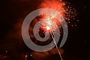 Red coloured New Year fireworks with smoke in background, fired above Nitra residental part during New Year celebration in 2021