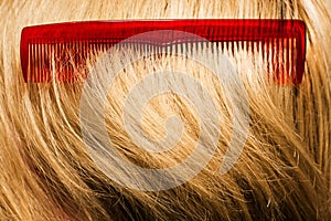 Red comb on blond hair