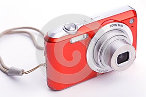 Red compact zoom digital camera over white