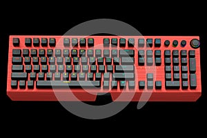 Red computer keyboard with rgb colors isolated on black background.