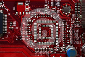 Red computer motherboard chip close-up with elements