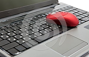 The red computer mouse on the black keyboard