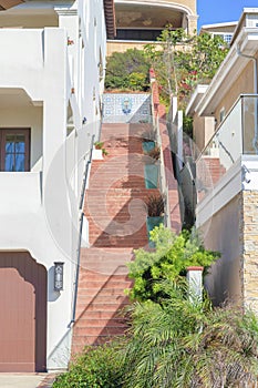 Red concrete stairs outside the building with potted plants on every landings