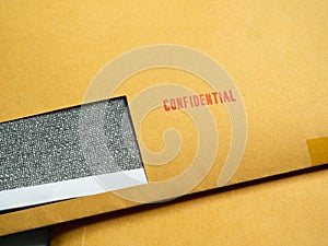 Red `Confidential` word printed on brown vintage envelope. Business confidential concep